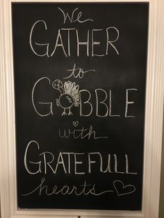 a chalkboard with the words we gather to gobble with grateful hearts written on it