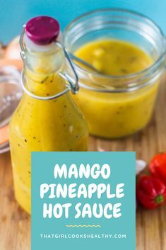 mango pineapple hot sauce in small glass bottles on a wooden cutting board with peppers