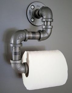 a roll of toilet paper is hanging on the wall next to a faucet