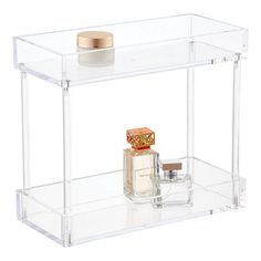 clear acrylic display case with perfumes and candle on white background, front view