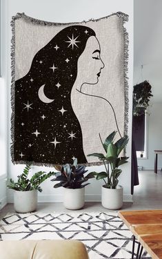 a woman's face with stars in the sky on a wall hanging over a couch