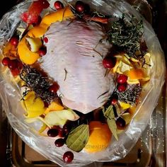 a turkey is wrapped in plastic and surrounded by fruit