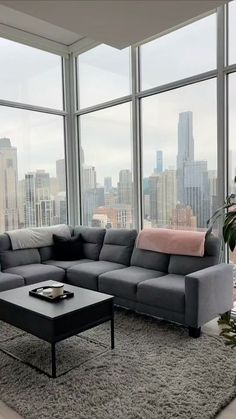 a living room with large windows and a couch in front of the floor to ceiling windows