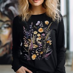 Long Sleeve Botanical Blossom Tee is a perfect embodiment of nature's beauty and a heartfelt Christmas gift for the special women in your life.  Crafted with care, this vintage style t-shirt showcases a captivating print of wildflowers, intricately designed to evoke a sense of timeless elegance. Its long sleeves offer both comfort and style, making it a versatile addition to any wardrobe.  Whether it's for a cherished mother, a devoted godmother, a beloved grandmother, or a cherished sister and friend, this tee is a token of appreciation that celebrates their unique grace.  Wildflowers Long Sleeve Tshirts are super-soft, a perfect blend of comfort and empowerment.  ❤️  Bella + Canvas *UNISEX* long-sleeve shirt fits like a well-loved favorite. Casually elegant with an excellent quality prin Cottagecore Tshirt, Long Sleeve Tshirts, Floral T Shirt, Casually Elegant, Flowers Vintage, Boho Floral, Pressed Flowers, Vintage Stil, Vintage Tshirts