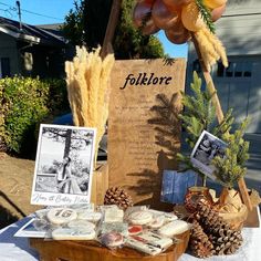 a table topped with pine cones and other items on top of a white table cloth