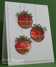 three christmas ornaments hanging from strings on a card