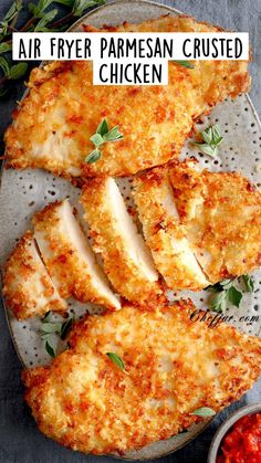 air fryer parmesan crusted chicken on a plate with sauce and herbs