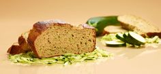 a loaf of zucchini bread sitting on top of a pile of shredded green vegetables