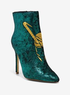 a green high heeled shoe with gold letters on the side and an arrow painted on it