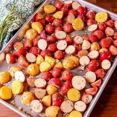 a pan filled with potatoes and carrots on top of a wooden table