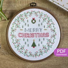 a cross - stitch christmas wreath with the words merry christmas on it