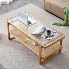 a coffee table with a laptop and magazines on it in the middle of a living room