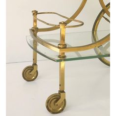 a glass and brass trolley with wheels