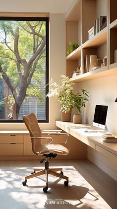 an office with a desk, computer chair and large window overlooking the trees in the yard