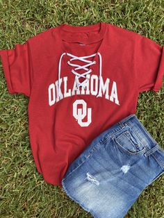 "OU grommet line v-neck tee with white knit ties will be great to wear to the up coming football games.  You can choose original hem, crop (20\" from back neck to hem) or crop top with front ties.    100% cotton PLEASE NOTE:  the second picture is  the new tee that is available.  That will be the one I will be using this season. In addition to the crimson color tee ( in the pictures) other colors available are white and black. Please let me know.  If you would like a lace inset instead of the grommet lined v-neck, message me.  6 1/2 depth of v-neck Wash wash, inside out, line dry flat" Sports Fan Tops For Game Day In Spring, Varsity Tops For College Spring Season, Varsity Tops For College In Spring, Spring Varsity Tops For College, Summer Collegiate Top For College, Casual Tops For Cheerleading In Fall, College Style Short Sleeve Tops For Game Day, Collegiate Summer Fan Gear Tops, Collegiate Style Tops For Game Day In Summer