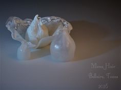 two white vases sitting next to each other on top of a table in front of a gray background