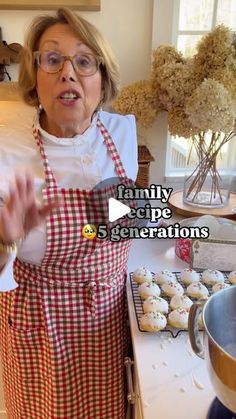 a woman in an apron making cupcakes on the kitchen counter with her hands out