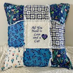 a decorative pillow with an all you need is love and a cat embroidered on it