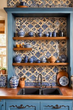 a kitchen with blue and white tiles on the wall, shelves above the sink and wooden counter tops