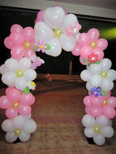 an arch made out of balloons with flowers