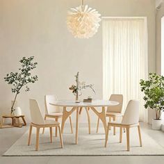 a dining room table with white chairs and a chandelier hanging from the ceiling