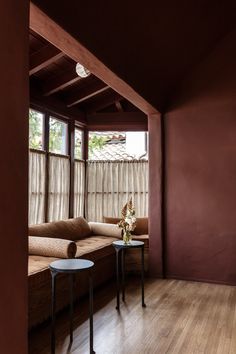 a living room filled with furniture next to a wooden floor covered in curtains and windows