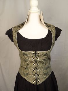 a mannequin wearing a black and green dress with laces on the waist