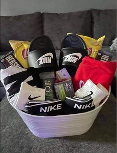 a basket filled with nike slippers, socks and other personal items sitting on a couch