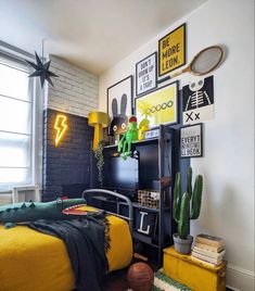 a bedroom decorated in yellow and black with pictures on the wall