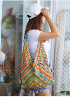 a woman carrying a multicolored crocheted bag