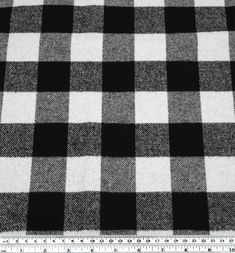 a black and white checkered fabric with a ruler in front of the plaid pattern