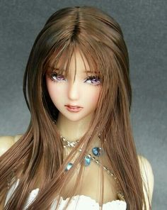 a close up of a doll with long hair and necklaces on it's neck