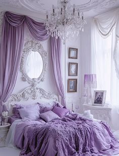 a white and purple bedroom with chandelier, bed, curtains and pictures on the wall