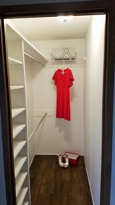 an empty closet with shoes and a red dress