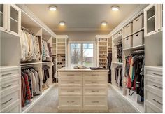 a walk in closet filled with lots of white drawers