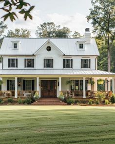 a large white house sitting on top of a lush green field