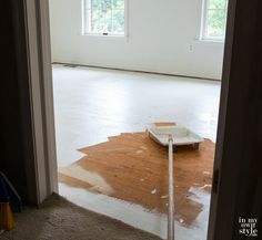 an empty room with some paint on the floor and a tape measure in front of it