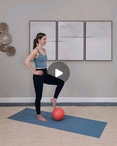 a woman is standing on a yoga mat with an exercise ball in front of her