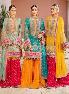 three women in colorful outfits standing next to each other