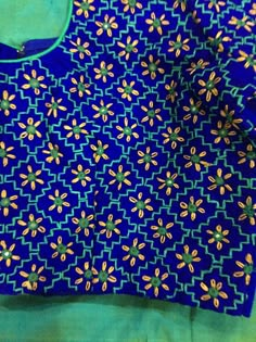 a blue shirt with yellow and green designs on the front, sitting on a table