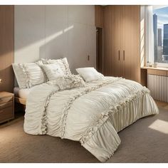 a large bed sitting in a bedroom next to a window with the city skyline behind it