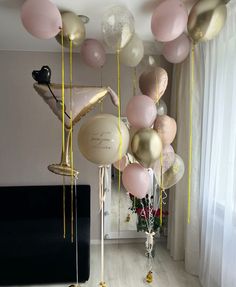 balloons and streamers hanging from the ceiling in a room with a mirror on the wall