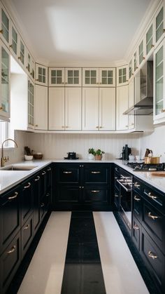 a kitchen with black cabinets and white counter tops