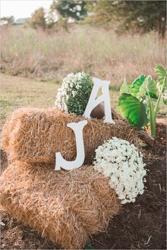 a hay bale with flowers and letters on it