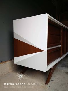 a white and brown cabinet sitting on top of a floor