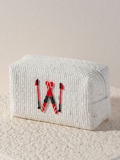 Carry all your odds and ends in subtle seasonal style with Shiraleah's Slope Zip Pouch! This petite pouch is the perfect size to store makeup, jewelry, and anything else you might need to keep in one place on your next ski trip. Made from trendy tweed fabric in a subtle ivory color with a subtle sparkle of lurex thread, the compact cosmetic case features an adorable embroidered design of a pair of red skis and poles. Pair with other items from Shiraleah's Apres Ski Collection to complete your lo Functional Cosmetic Bag With Zipper Pouch As Gift, Functional Cosmetic Bag With Zipper For Gift, Functional Zipper Pouch As Gift, Functional Zipper Pouch For Gifts, Functional Pouch Cosmetic Bag As Gift, Spa Wraps, Accessories Display, Odds And Ends, Tweed Fabric