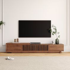 a flat screen tv sitting on top of a wooden entertainment center in a living room