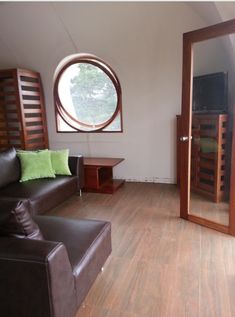 a living room with a couch, chair and large round window