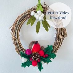 a bird sitting on top of a wreath with pine cones and holly decorations around it