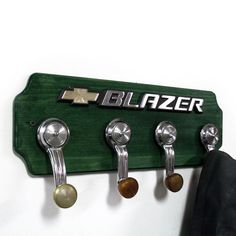 a coat rack with four hooks and three knobs on the bottom one has a nameplate that says blazer